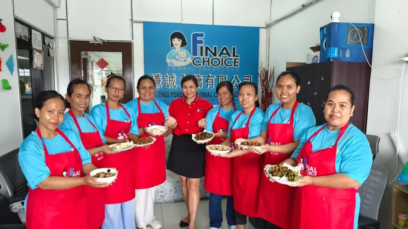 Trainees and a Final Choice team member holding bowls of food they prepared, in front of our company banner