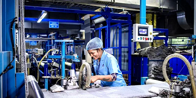 Production worker operating machinery on a factory floor